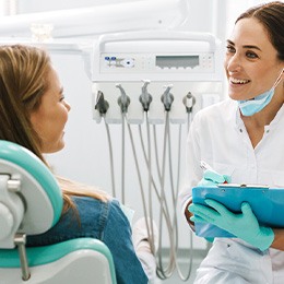 Smiling dentist taking notes on clipboard