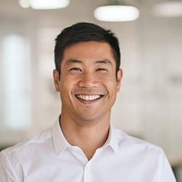 Man standing in office and smiling