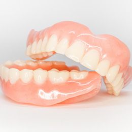 Full set of dentures against neutral background