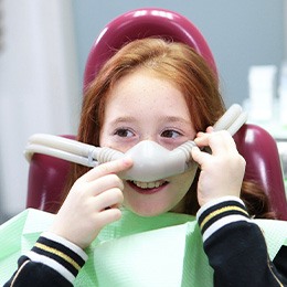 Child smiling while holding nasal mask