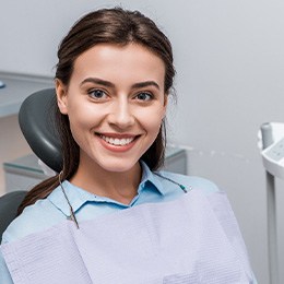 Female patient sitting in dental chair and smiling