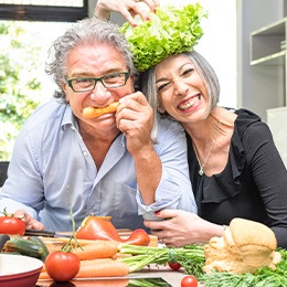 A happy senior couple preparing healthy foods to eat