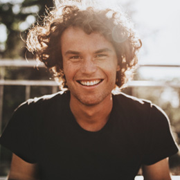 Man sitting on bleachers and smiling