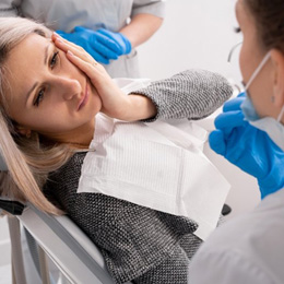 Lady looks to dentist with oral pain