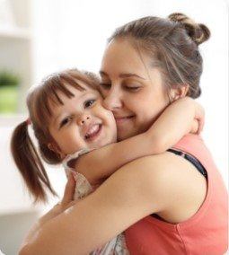 woman hugging smiling child