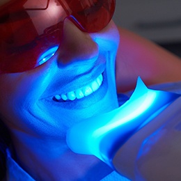 A female dentist talking to her smiling male patient