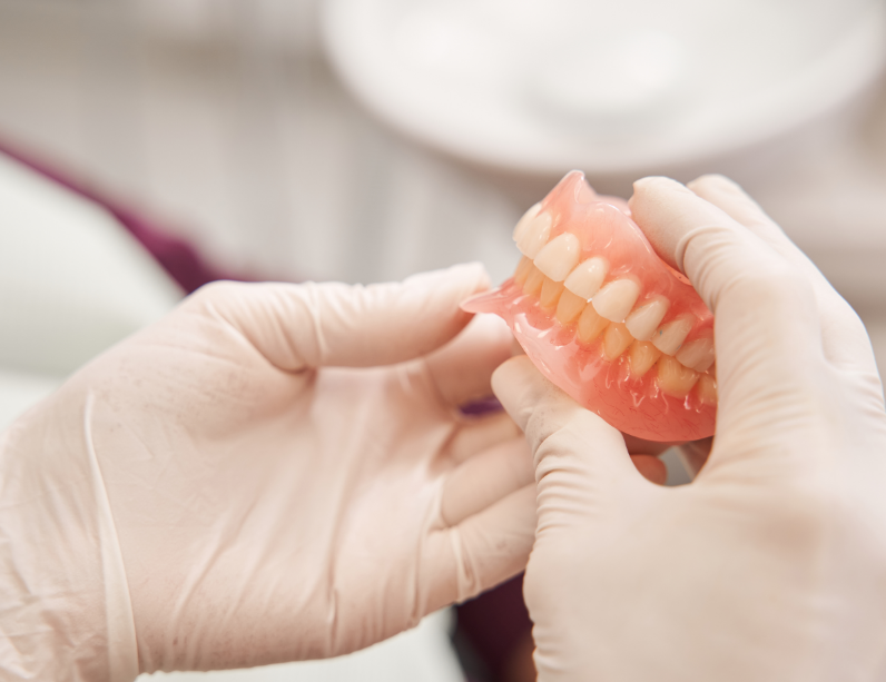 Dentist holding dentures